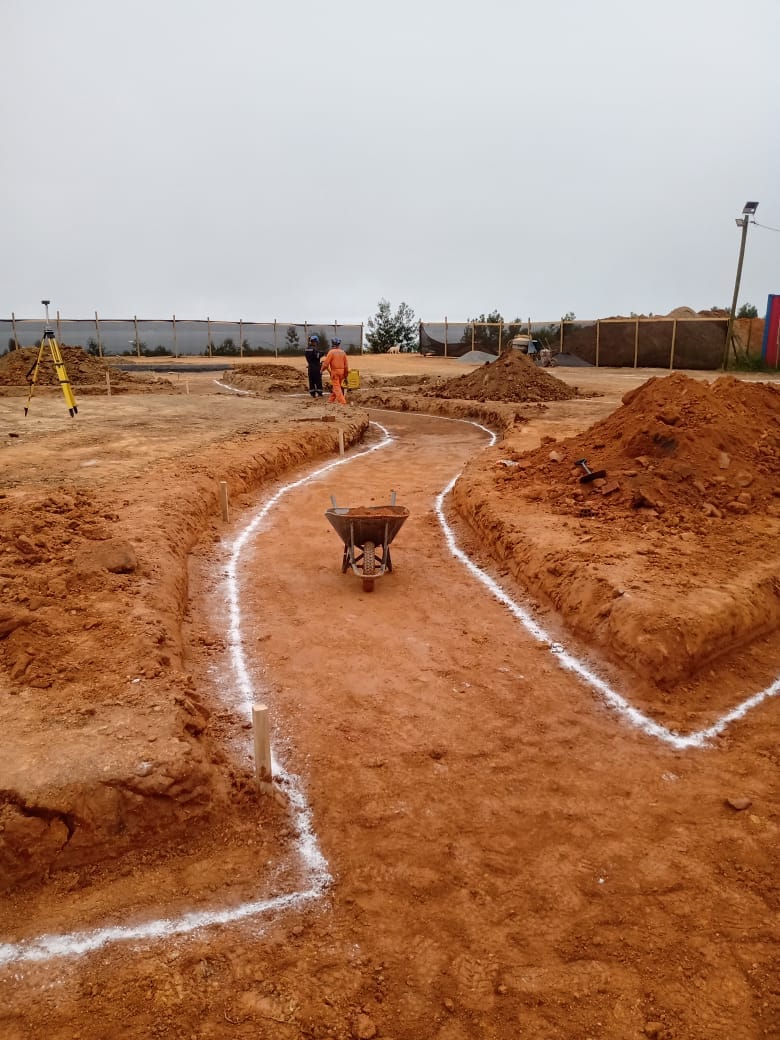 Senderos de la plaza marcados con cal en terreno, con estación total al fondo