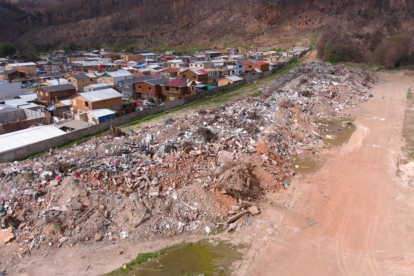 Registro fotográfico en terreno de escombros acumulados junto a viviendas